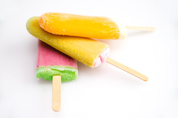 Three ice creams of different colors are stacked on a white background. Summer refreshing dessert.