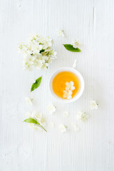 Cup of jasmine herbal tea with white flowers. Top view