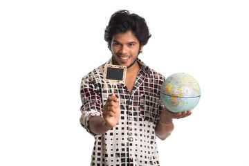 young man holding a world globe and a small board on a white background.