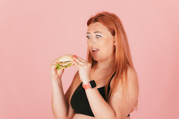 Hungry redhead oversize woman eating fast food burger
