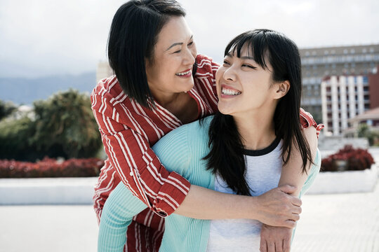 Asian mother and daughter having fun outdoor - Main focus on girl face