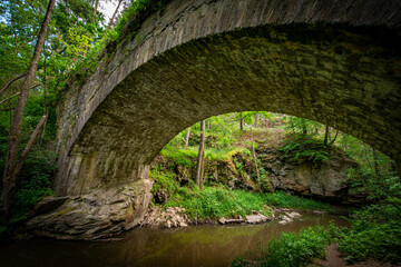 a big stone bridge, river and green forest