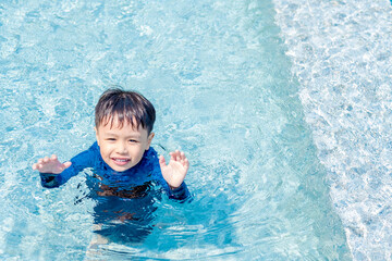 Fototapeta na wymiar Happy little boy learning to swim. Selective focus. Copy space.