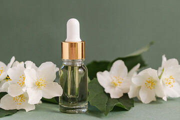 Cosmetic glass bottle for essential oils with jasmine flowers on green background. Spa Natural Serums. Dropper Bottle Mock-Up. Herbal Medicine or Cosmetics