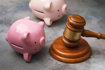 Judge gavel and inverted piggy banks, debt collection concept