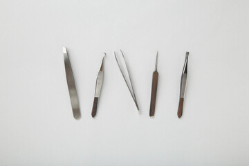 Beauty and fashion concept - tools for Eyelash Extension Procedure. Tweezers on grey background. Copyspace mockup