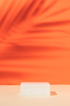 Minimal modern product display on orange background with podium with tropical palm leaf shadow. Suitable for Product Display and Business Concept.