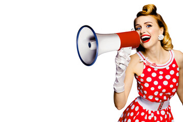 Beauty blond haired woman holding megaphone, shout something. Girl in red pinup style dress in polka dot, isolated over white background. Female model in retro and vintage studio concept.