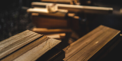 Background image of furniture woodworking workshop, carpenters industrial wooden material work table with different craft tools and wood cutting stand, vintage filter image.