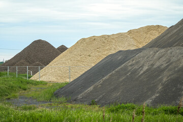 Different colored hills of sand, gravel, cement and building materials under the blue sky....