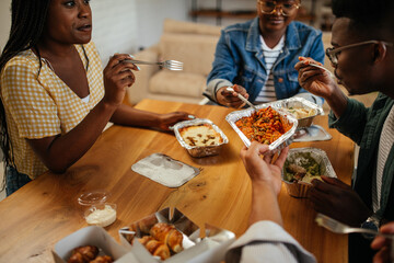 Black friends ordering and eating delivery food at home