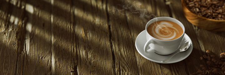 Frische Tasse Kaffee auf Tisch aus Holz mit Kaffeebohnen