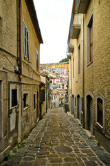 A small street between the old houses of Muro Lucano, a medieval village in the mountains of the Basilicata region in Italy