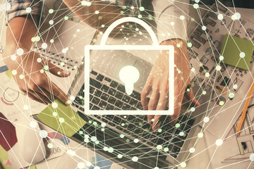 Double exposure of man and woman working together and lock hologram drawing. Security concept. Computer background. Top View.