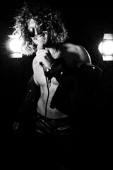 Handsome male performer with long hair, beard and wearing shades with open shirt revealing sixpack...