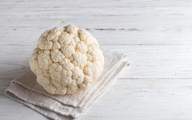 Whole raw organic cauliflower on a white wooden background. Fresh vegetables. Harvest. Vegetarian and vegan food. Selective focus, copy space - 439845355