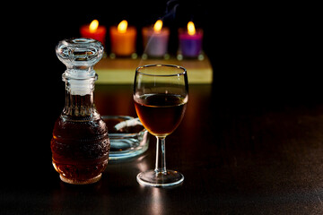 glass of alcohol and bottle with cigarette isolate on black 