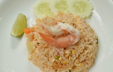 fried rice shrimp and egg with slice cucumber couple lemon on plate