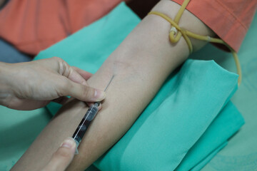 Close up Hand of nurse, doctor or Medical technologist in blue gloves taking blood sample from a...