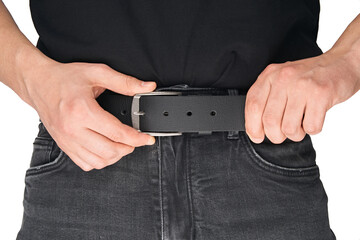 A man in black jeans puts on a belt. Jeans belt. Black leather belt. Buckle.