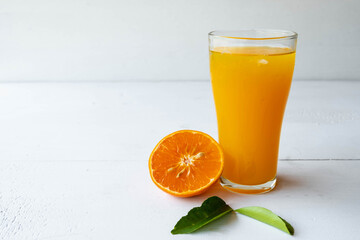 Freshly squeezed orange juice and orange fruit cut in half