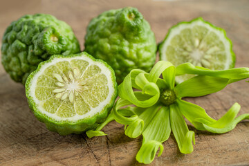 Fresh bergamot fruit with cut in half on wooden background.