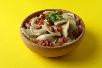 Concept of tasty food with vareniki or pierogi on yellow background