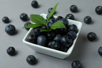 Fresh blueberry with leaves on gray background