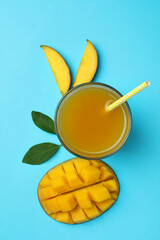 Ripe mango fruit and juice on blue background