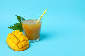 Ripe mango fruit and juice on blue background
