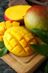 Tasty ripe mango fruit on black smokey table