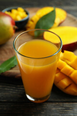 Ripe mango fruit and juice on wooden table
