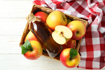 Homemade apple vinegar and ingredients on white wooden table