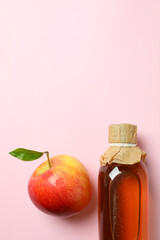 Homemade apple vinegar and ingredient on pink background