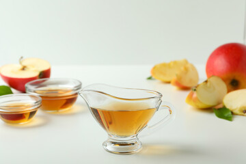 Homemade apple vinegar and ingredients on white table