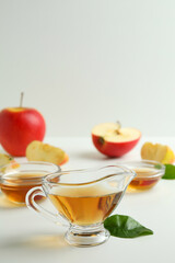 Homemade apple vinegar and ingredients on white table