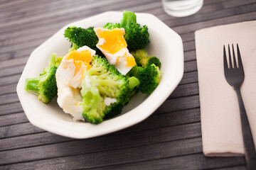 healthy food. steamed broccoli inflorescences with boiled egg in a bowl