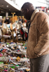 African American man chooses antiques on the flea market