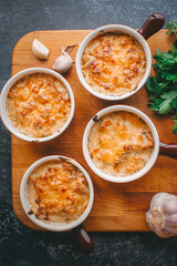 Julienne in portions, Mushrooms with cream and cheese casserole, Restaurant food on a dark background, Top view