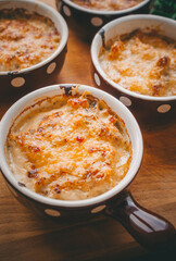 Julienne in portions, Mushrooms with cream and cheese casserole, Restaurant food on a dark background, Top view