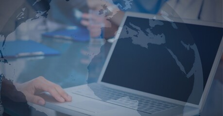 Globe against mid section of man using laptop at office