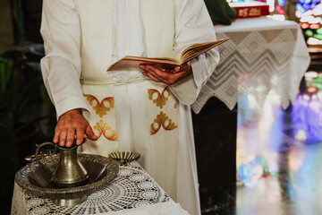 White-robed priest conducting a marriage with holy water and bible