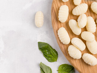 Gnocchi is a traditional vegetarian italian dish on a wooden board. Gray background. Copy space
