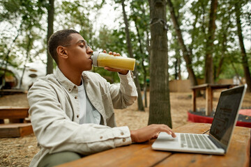 Young african american man freelancer drinking juice
