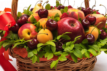 Basket with fresh fruits and berries on a white background