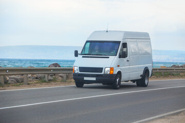 minibus moves along the road along the sea