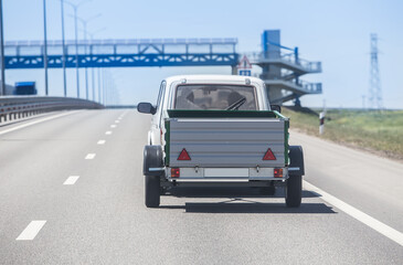 Obraz na płótnie Canvas Car with a Trailer moves along highway