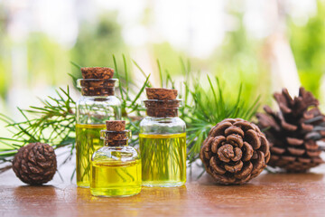 Cedar and spruce essential oil in small glass bottles on wooden background. Selective focus