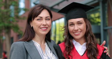 My dear. Graduation day celebration concept. Happy brunette graduate female hugged by her proud mother at the graduation day celebration. Education concept