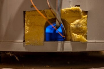 Hot water heater pilot light and burner visible with base plate removed © Lost_in_the_Midwest